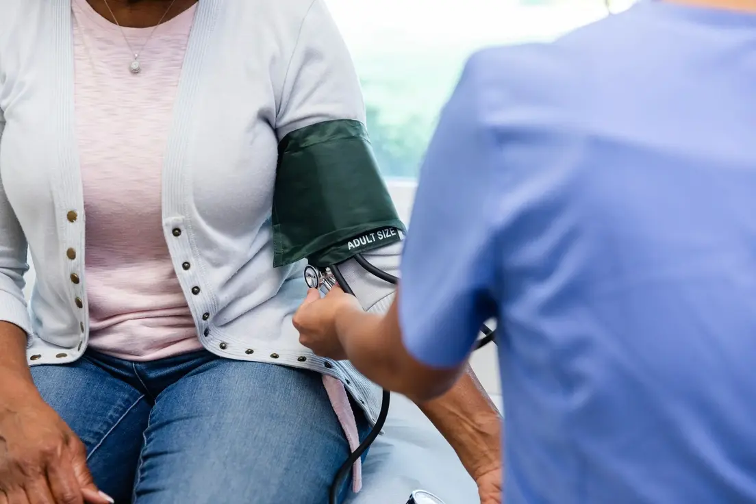 Infermiera che misura la pressione a un anziano